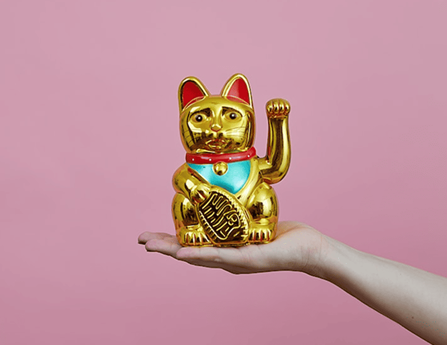 写真:手の上に金色の招き猫が乗っています
